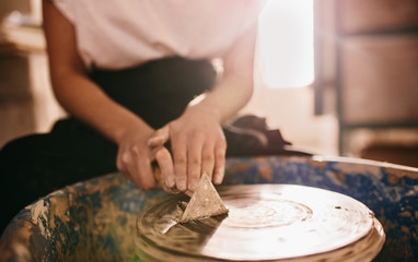 Fototapeta na wymiar Female potter working on potters wheel
