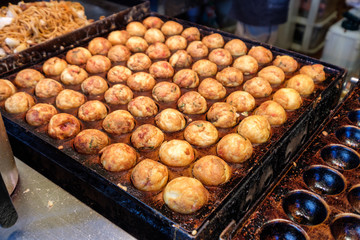 Cooking Takoyaki grilling on steel pan, Traditional Japanese food