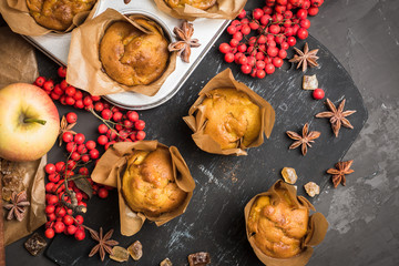 Muffins with pumpkin and apples on the rustic background with autumn decorations. Selective focus.