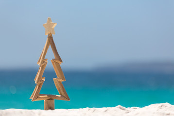 Timber Christmas tree in sand on the beach - 183078634
