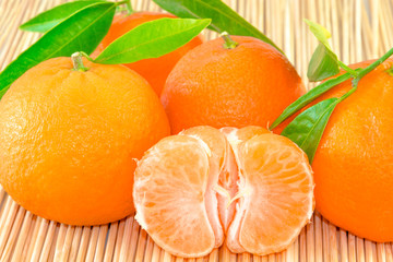 Tangerines with leaves and slices on wooden sticks