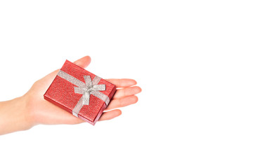 Dłoń z prezentem na Boże Narodzenie. Dłoń z czerwonym pudełkiem prezentowym.
