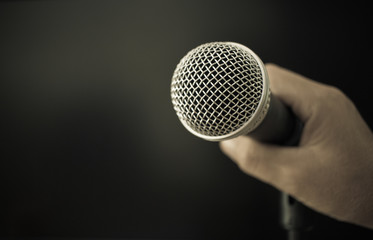 Hands holding Retro Microphones on front stage in pub bar or restaurant. Classic sing a song in...