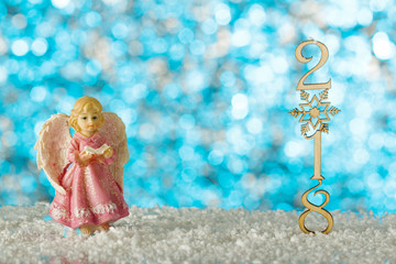 Christmas card with angel. Snow drifts and figures 2018. Blurred background.