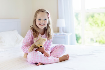 Kids in bed. Children in pajamas. Family bedroom.