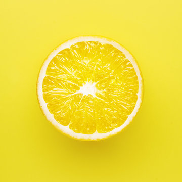 Juicy yellow slice of lemon on a yelow background isolated