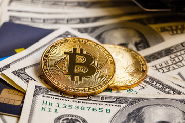 Golden bitcoin with credit card on top of dollar banknote background new currency accepting