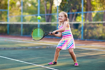 Fototapeta na wymiar Child playing tennis on outdoor court