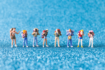 Obraz premium Miniature Backpacker , Tourist people on blue glitter background