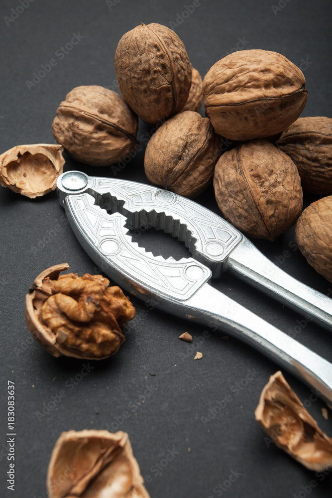 Poster fruits of a walnut on a black table close up. whole and open, the core of the nut. nutcracker.