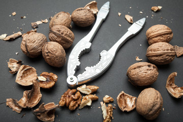 Metal vintage nutcrackers with walnuts on a black background.