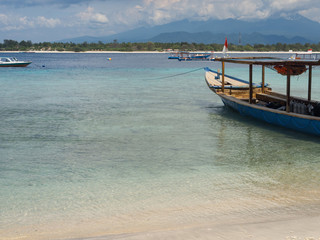 Obraz premium Beautiful tropical lagoon on a deserted island with boat in foreground. Gili, Indonesia, 2017