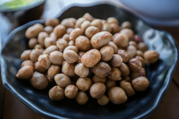 Side view of boil chickpeas on beautiful black plate.
