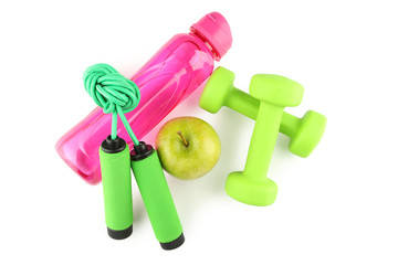 Pink water bottle, green apple, dumbbells and skipping rope isolated on white