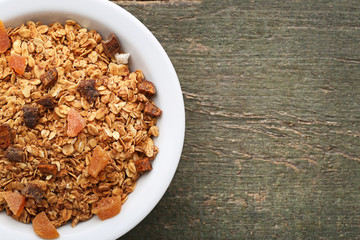 Tasty granola in plate on grey wooden table