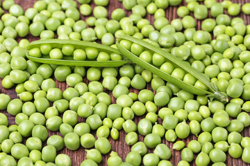 Fototapeta na wymiar Fresh green peas on brown wooden table