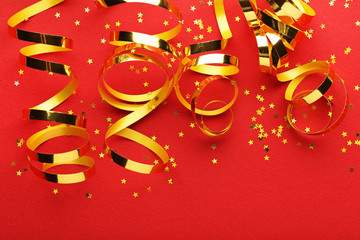 Golden ribbons with confetti on red background