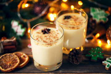Eggnog in glasses with star anise on wooden table
