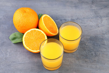 Glass of orange juice on grey wooden table