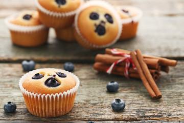Sweet blueberry muffins with cinnamon on grey wooden table