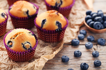 Sweet blueberry muffins on grey wooden table
