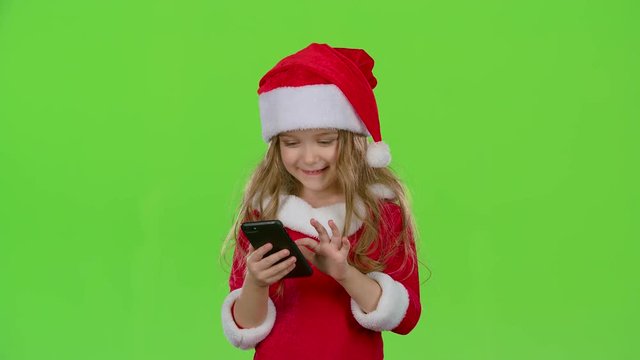 Child girl in an embrace photographed on a smartphone. Green screen. Slow motion