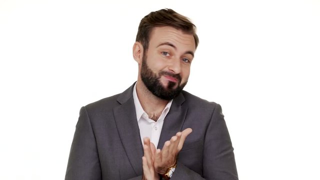 Portrait of cunning man in suit gesturing with both hands meaning oops sorry pretending he has no idea what happened or he do nothing over white background. Concept of emotions