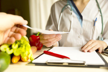 Vegetable diet nutrition and medication concept. Nutritionist is giving prescription and offers...