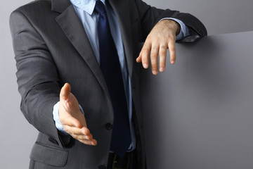 Man wearing a suit offering to shake hands