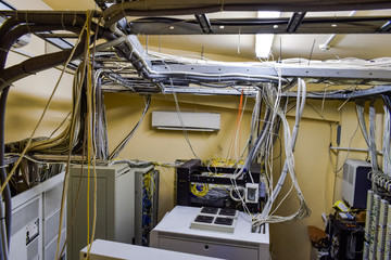 A set of wires and cables intertwined in datacenter server room. Top view of the control room