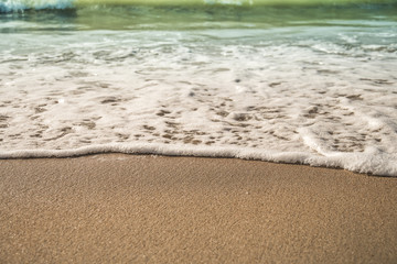 Background soft wave of Sea with foam on sandy beach.