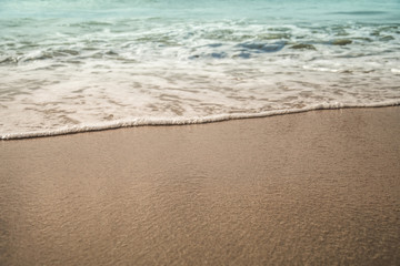 Background soft wave of Sea with foam on sandy beach.