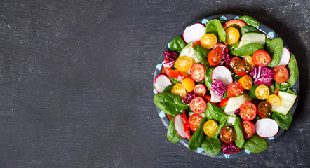 plate of fresh salad on dark background