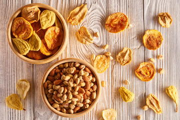 Dried fruits and nuts on wooden background