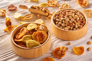 Dried fruits and nuts on wooden background
