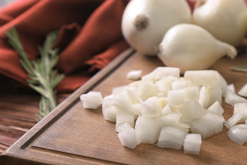 Wooden board with sliced onion on table, closeup