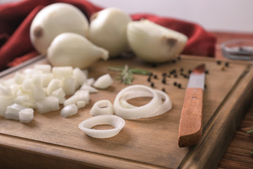Wooden board with sliced onion on table, closeup