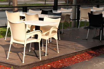 Empty plastic tables and chairs of coffee shop on the street selective focus