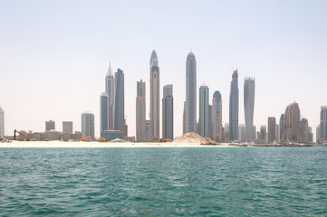 Fototapeta na wymiar Construction and construction machinery in front of Dubai Marina in a spring day, Dubai, UAE.