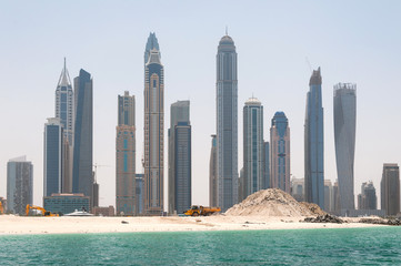 Fototapeta na wymiar Construction and construction machinery in front of Dubai Marina in a spring day, Dubai, UAE.