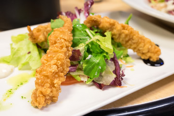 Tempura shrimps with lettuce and arugula salad served with herbs, olive oil and mayonnaise sauce