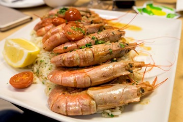 Seafood risotto (rice) with grilled prawns and cherry tomatoes