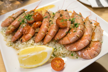 Seafood risotto (rice) with grilled prawns and cherry tomatoes