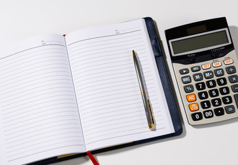 Blank notebook with pen and calculator on the desk