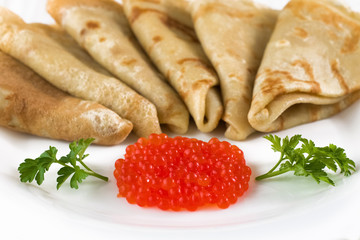 Red caviar in a plate with pancakes and parsley