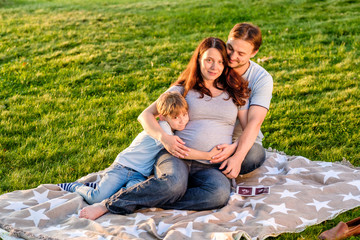 Naklejka na ściany i meble Happy pregnant family of three expecting new baby