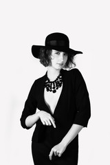 Black and white portrait, woman look at camera with hat, play with jacket on naked body, accessories, long skirt, bw, isolate