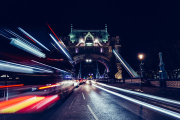 Fototapeta na wymiar City light trails of London bus traffic on Tower Bridge in London at night