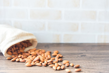 Almond baked in sack bags placed on old wooden floor.