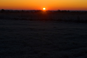 October sunrise on a frozen field. Pskov region, Russia